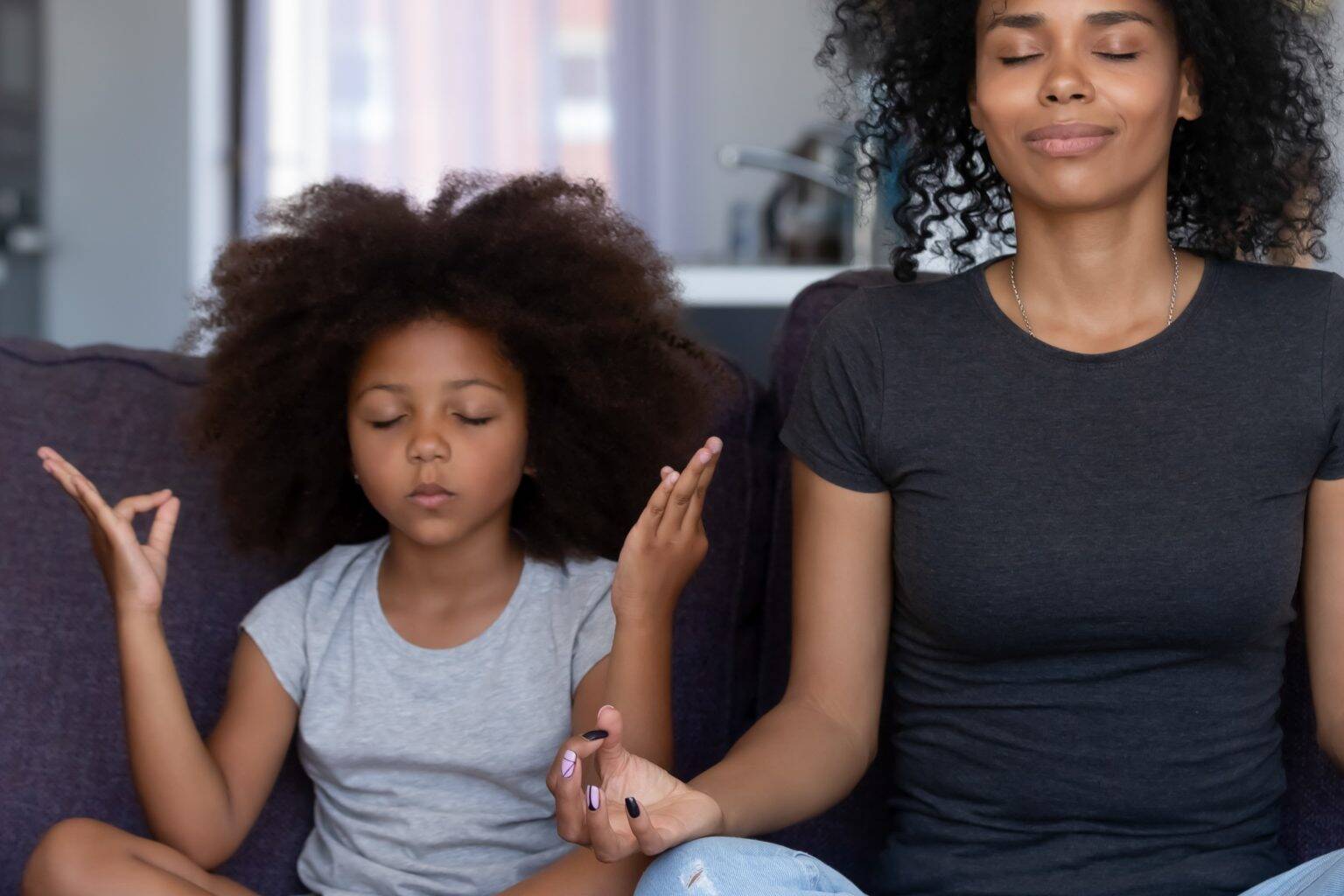Cardiovascular Health - Mother and daughter meditating together on a couch, embodying a serene approach to lowering stress and managing blood pressure naturally with meditation techniques.