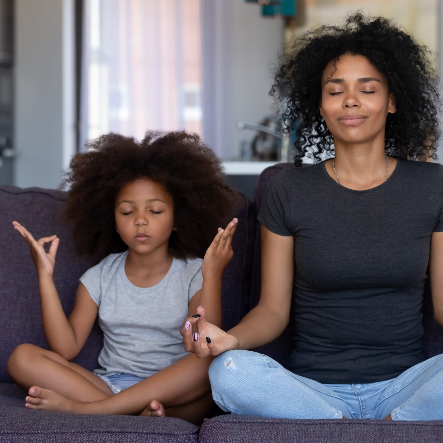 Cardiovascular Health - Mother and daughter meditating together on a couch, embodying a serene approach to lowering stress and managing blood pressure naturally with meditation techniques.